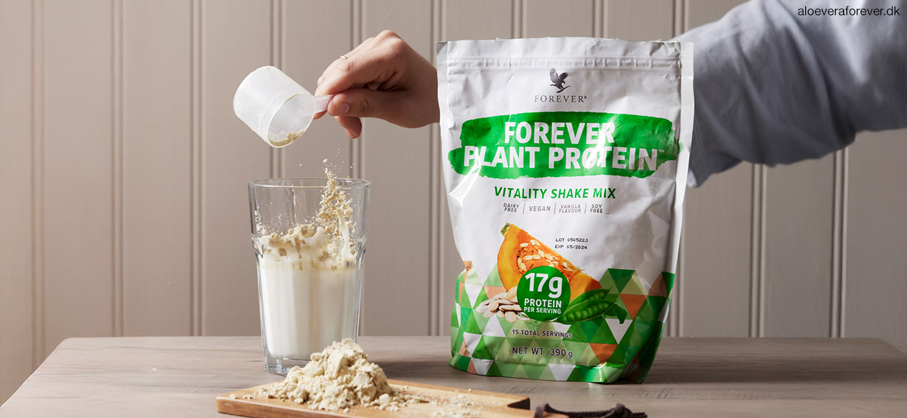 Forever Plant Protein ærteprotein og græskarprotein pulver hældes i glas med scoop ske