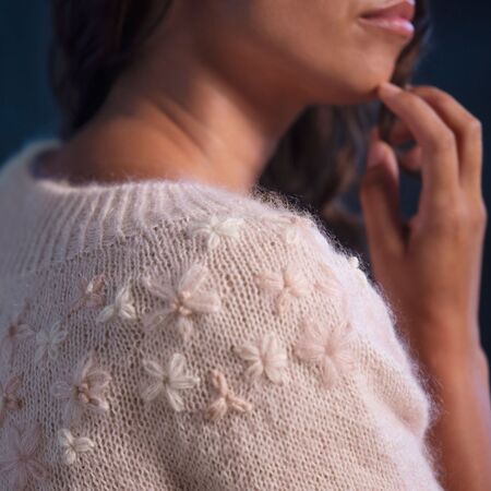 close up af model ifoert daysi strikket bluse fra hanne rimmen og filcolana