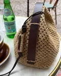 Close up af Læderrem og Juno bag fra PetiteKnit på bord