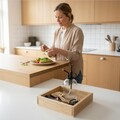 Kvinde anretter mad i køkken med tilbehørspakke til mikrogrønt i forgrunden