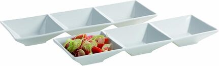 Fire hvide, rektangulære serveringsfade er arrangeret i to rækker. Tre er tomme, og en indeholder en salat med salat og cherrytomater.