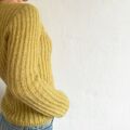 Cascade Blouse af Odd Row set fra siden. Strikket i gul Highland & Silk Mohair fra Isager med ribstruktur og kropsnær pasform.