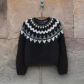 Anne Ventzels Selene Sweater i mørk brun og hvidt mønster hænger på væg