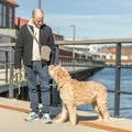 Mand med hund på gåtur og Trixie godbidstaske over skulderen