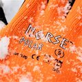Et nærbillede af Norse Polar arbejdshandsker i sort og orange, dækket af et lag sne. Dette viser handskernes evne til at håndtere kolde forhold med stil og funktionalitet.