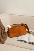 project 44 laedertaske fra re designed i farven burned tan ligger i en sofa