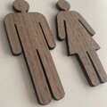 Minimalistisk toiletskilt i træ med dame og mand figur