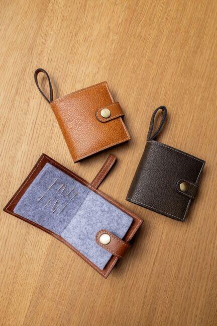 Project 76 nåleholdere i brun og mørkegrøn læder, vist åbne og lukkede.