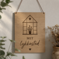 Mit lykkested skilt ophængt som dekoration i drivhus og have