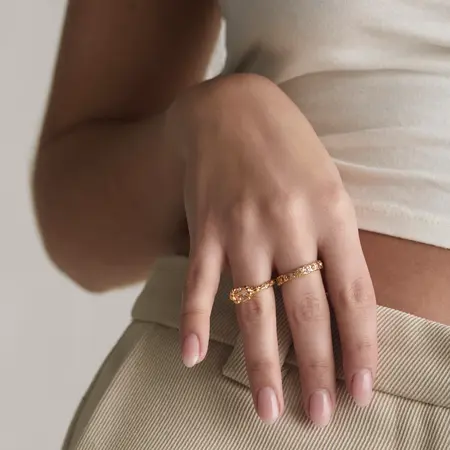 Model wearing Rosy Creek ring made of 925 pure sterling silver plated with 18 carat gold plating set with pink zirconia.