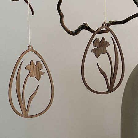 Påskeæg i træ med pinselilje ophængt i gren – forårspynt i eg og valnød