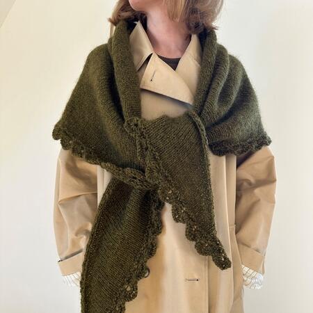 Model iført ellie shawl strikket i hjleholt dansk pelsuld 82 farven oliven