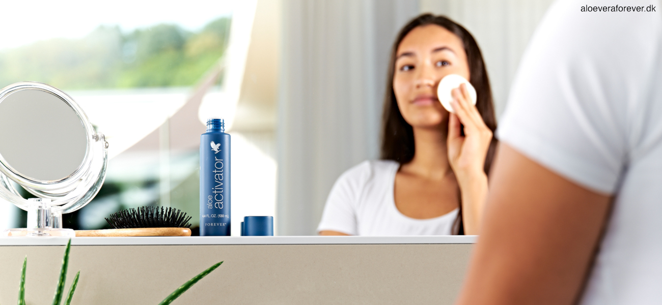 aloe activator fra Forever Living påføres af kvinde ved spejl