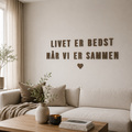 Bogstaver i træ Design 2 i valnød som vægdekoration med slogan i moderne stue