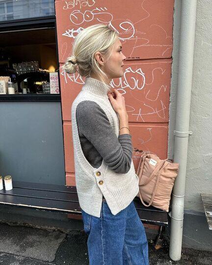 PetiteKnit Lulu Slipover strikket i Peer Gynt eller Peruvian Highland Wool – slipover med høj ribkrave, dybe ærmegab og knapper i siden båret over bluse.