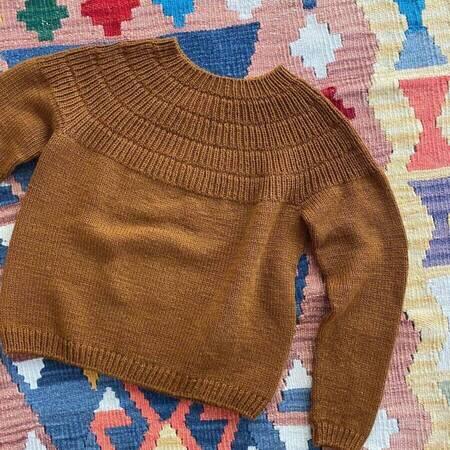 petiteknits strikkede ankers troeje my size i farven brun ligger paa sengen