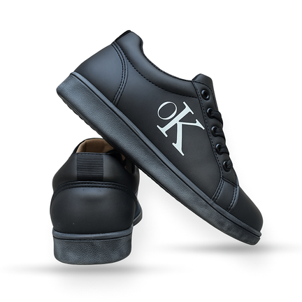 Sort lav sneaker med hvidt OK-logo og sort snørelukning
