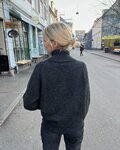 ryggen af petiteknit som staar paa gade ifoert sin zipper sweater light strikket i moerkt garn