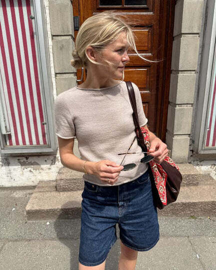 Model iført Ivy Tee fra PetiteKnit – enkel strikket T-shirt i glatstrik strikket oppefra og ned