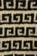 Nærbillede af Athene Sweater-mønsteret, sort grafisk mønster strikket i Isager Soft på beige bund.