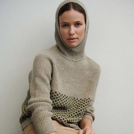 model kigger ind i kameraet hun bærer en agnes sweater designet af tine rousing strikket i isager garn