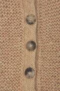 Nærbillede af Andrea Hood i lys sandfarve, fokus på knapper og tekstur i retstrik med tre knapper i synsfeltet.