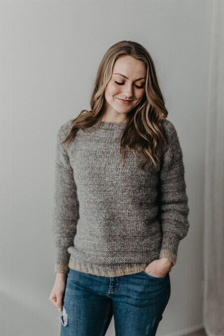 kvinde kigger skråt ned iført sin basic sweater fra camarose i grå