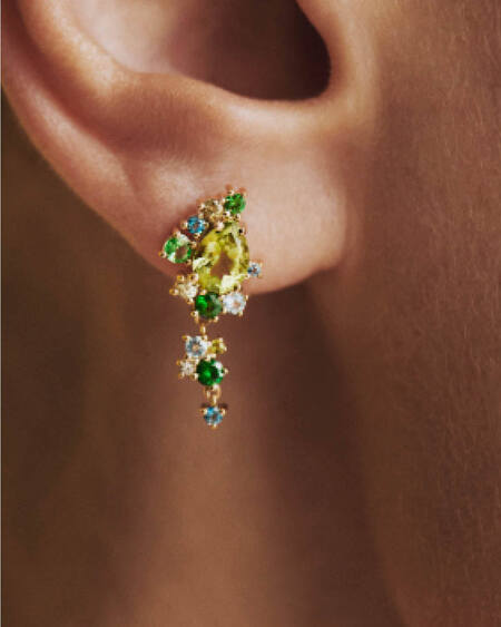 Model wearing FOUR SEASONS SPRING earrings in 14 karat gold with genuine stones: peridot, blue apatite, London blue topaz, green sapphire, tsavorite and green tourmaline
