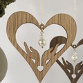 Elegant hjerte i træ med perle ophængt i gren – håndlavet julepynt