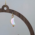 Detalje af måne charm med perle på juleornament i træ