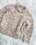 petiteknits marble sweater ligger paa sengen