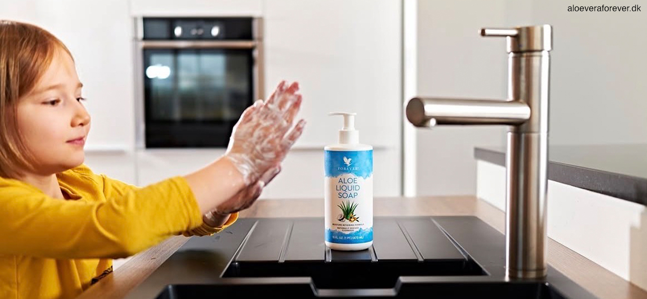 En lille pige i gul blus vasker hænder med Aloe Liquid Soap fra Forever Living
