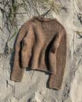 Petiteknits ivy sweater strikket i Isager soft e7s ligger på en strand