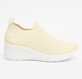 Cremefarvet slip-on damesneaker med strikket overdel og hvid komfortsål, vist fra højre side, venstre side og ovenfra på hvid baggrund.