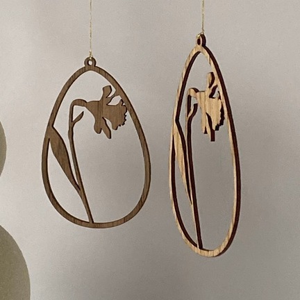 Påskeæg i træ med påskelilje ophængt i gren – dekorativ påskepynt